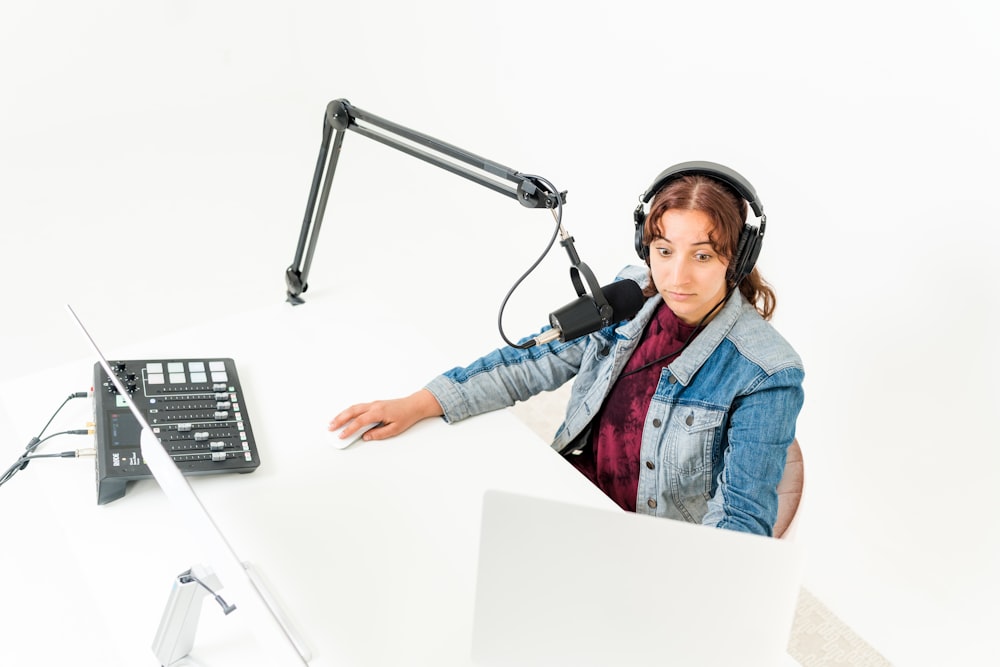 a person wearing headphones and sitting at a desk with a computer