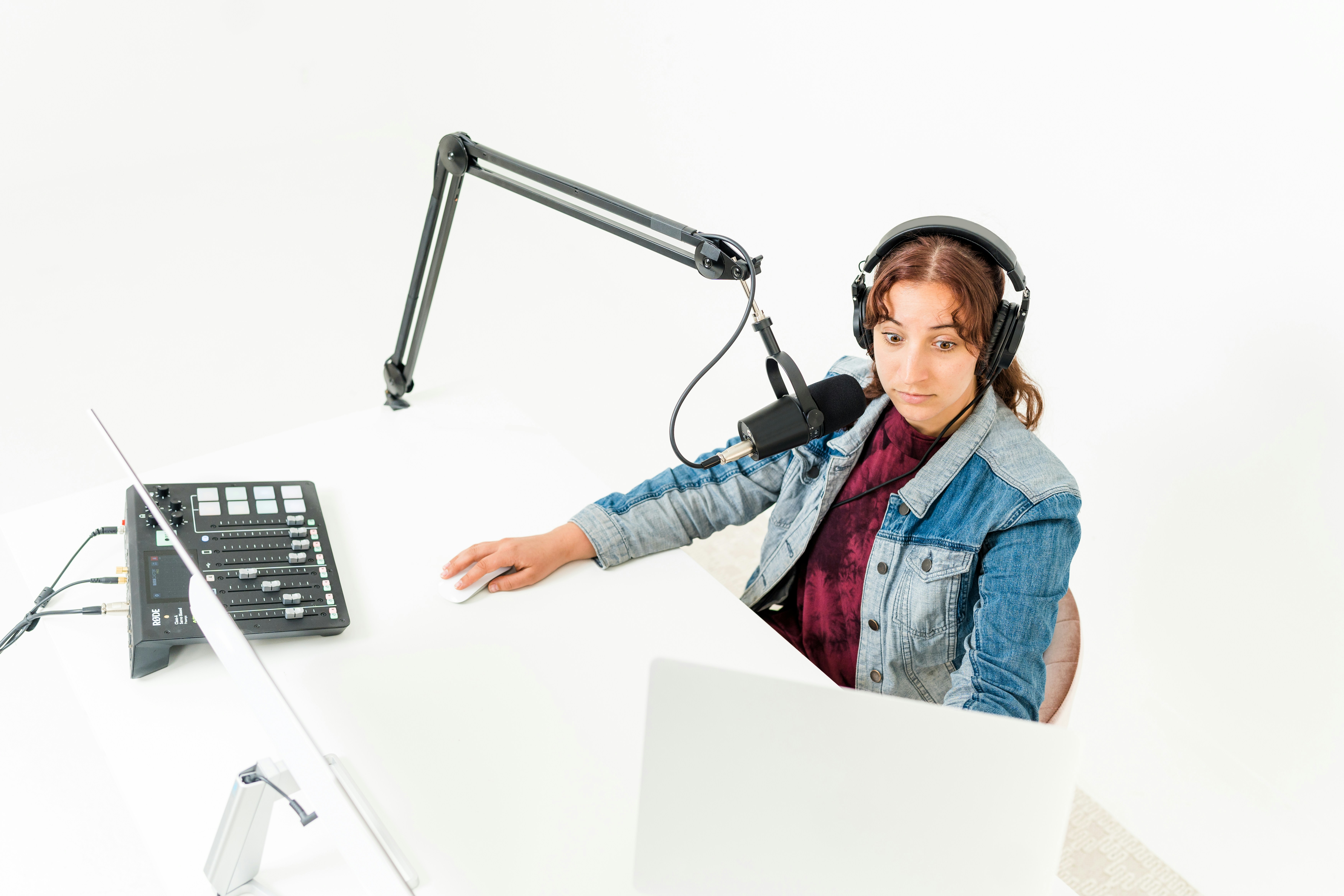 Woman recording podcast looking surprised with microphone