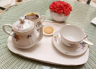 A delicate ceramic tea set with subtle glaze, arranged on a wooden tray.