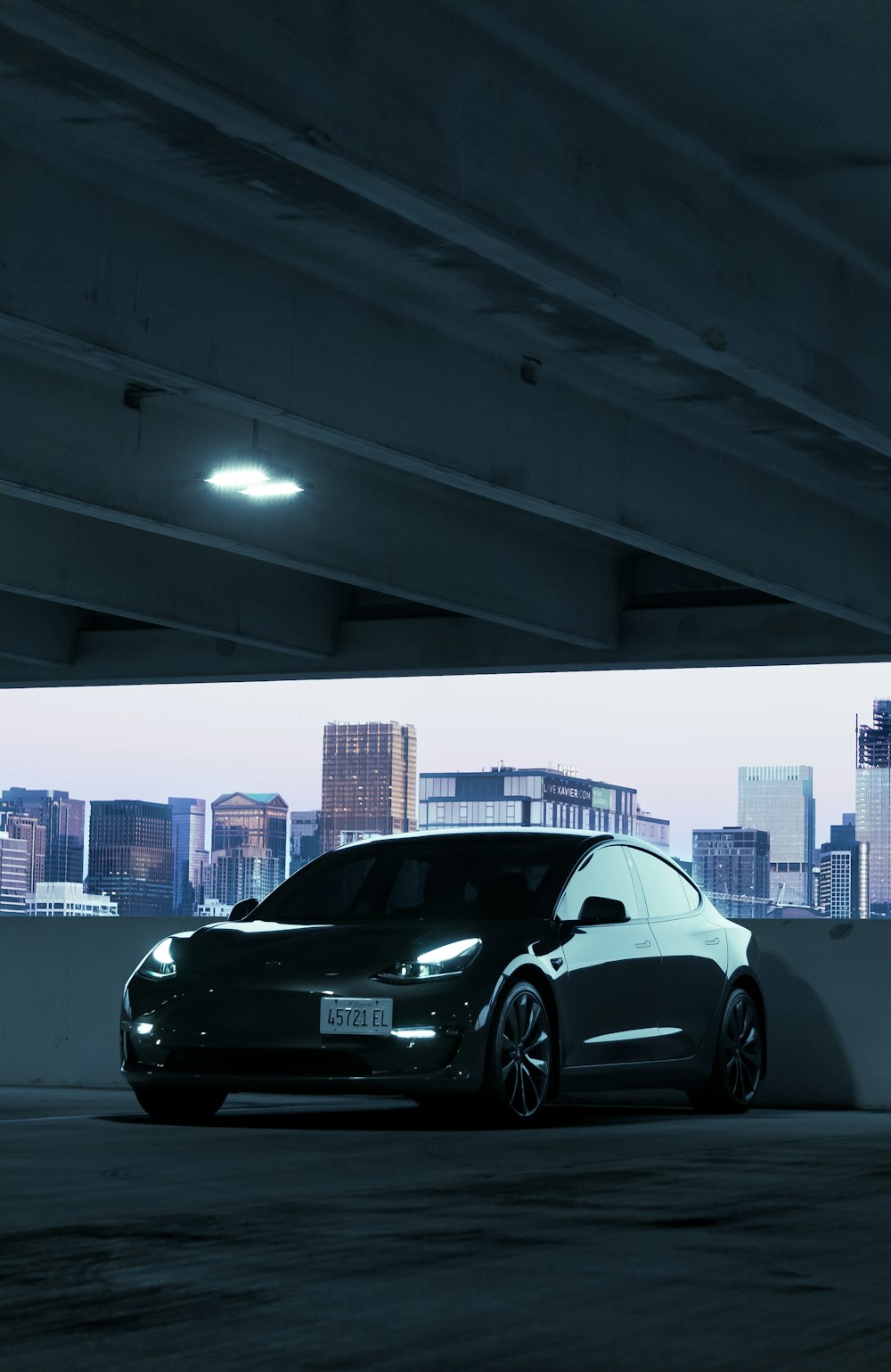 a black car parked under a bridge