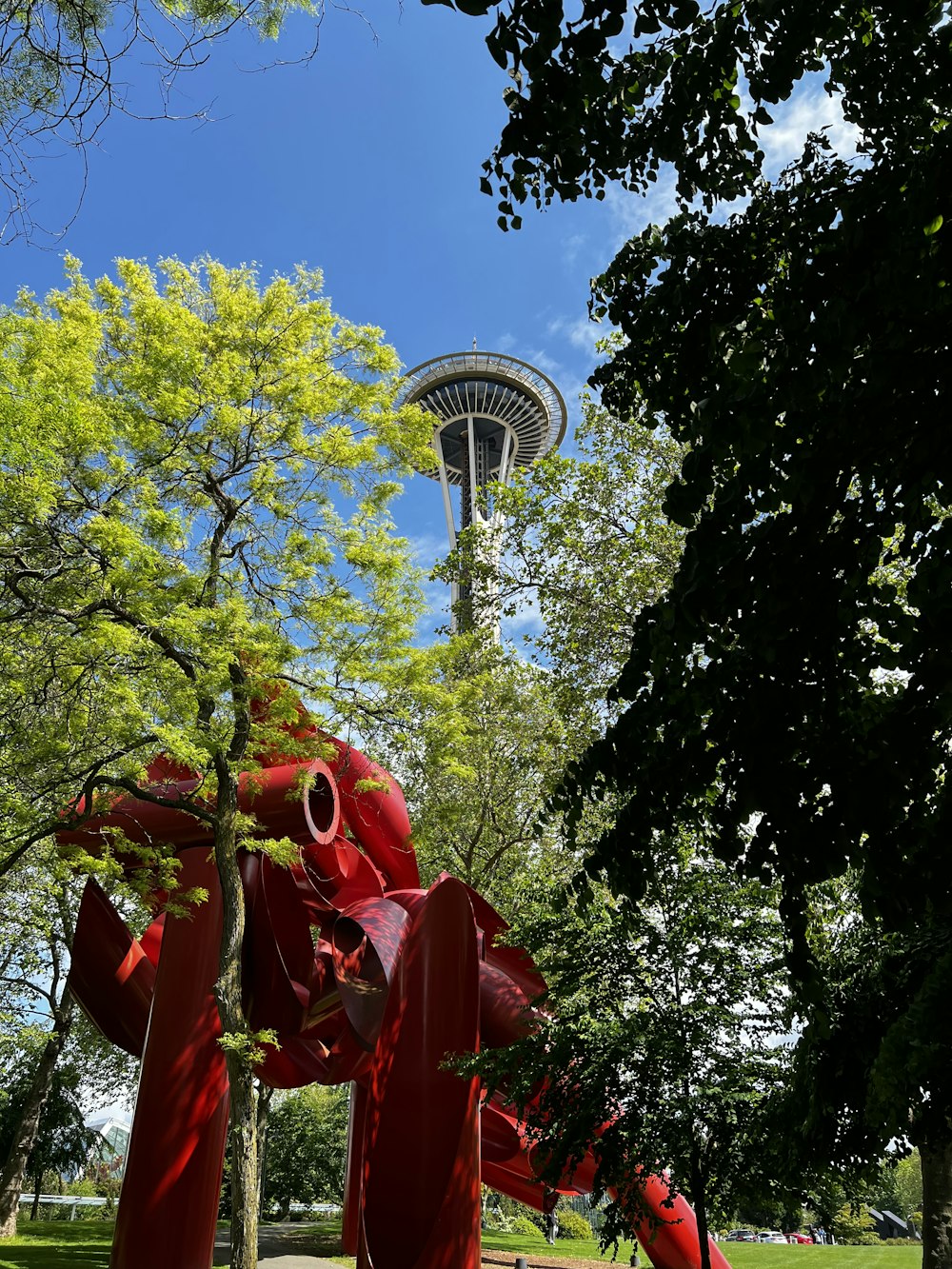 a red and green tree with a tower in the background