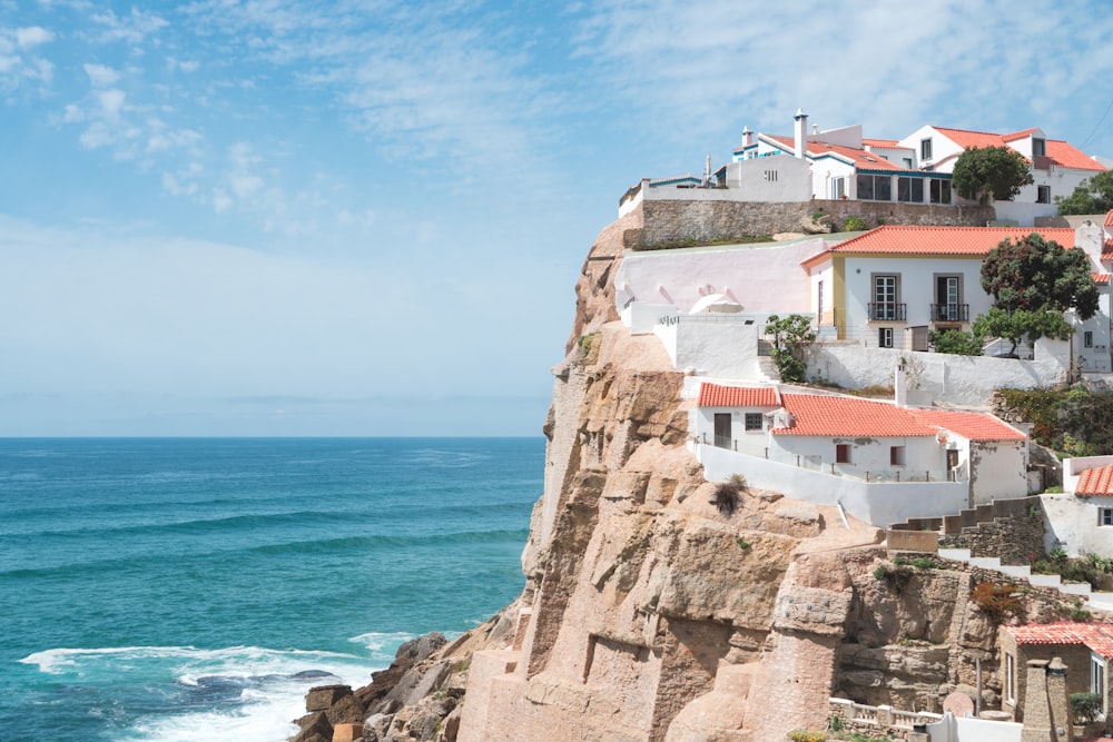 a group of buildings on a cliff by the ocean