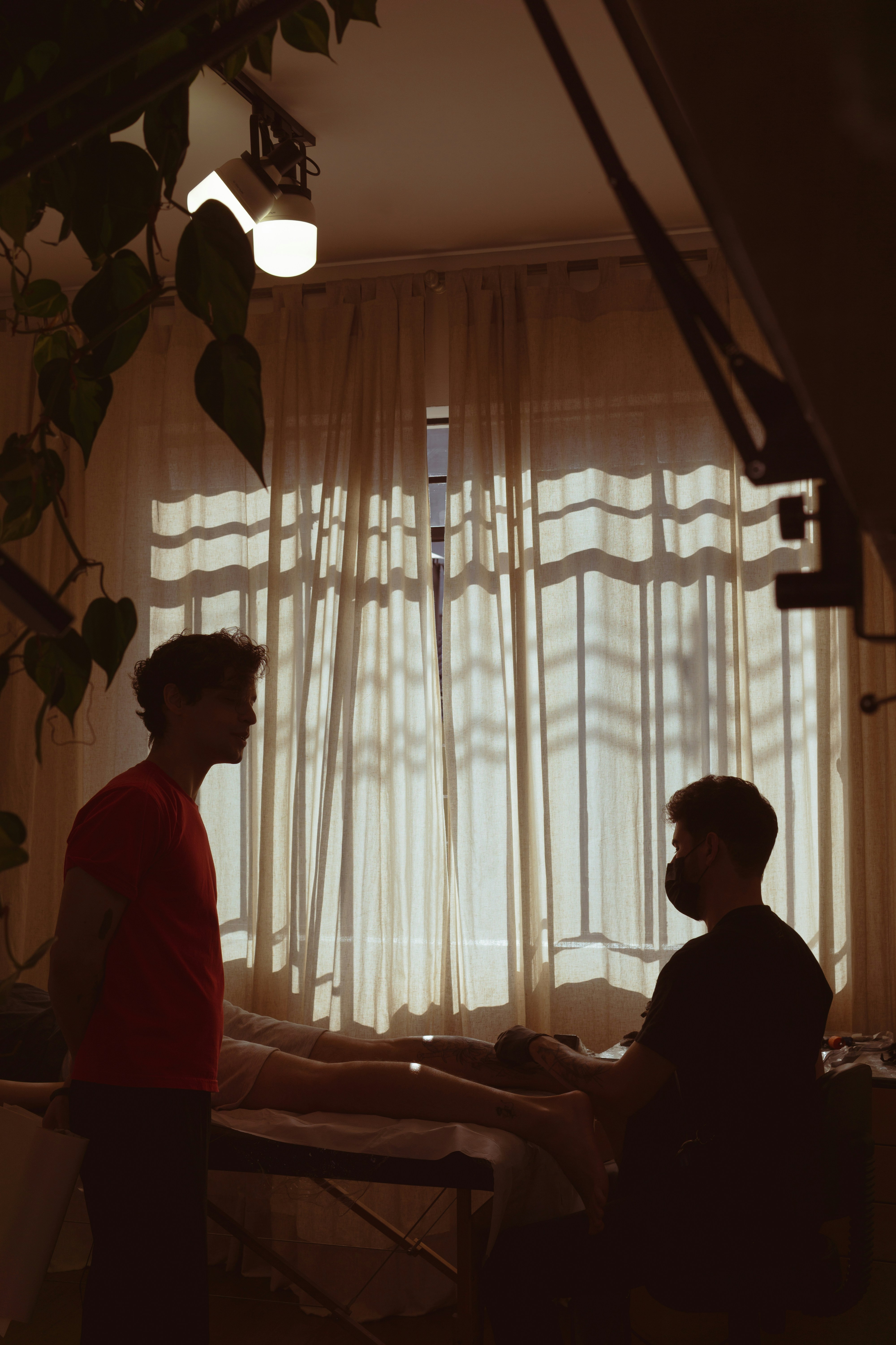 a couple of men sitting at a table in front of a window