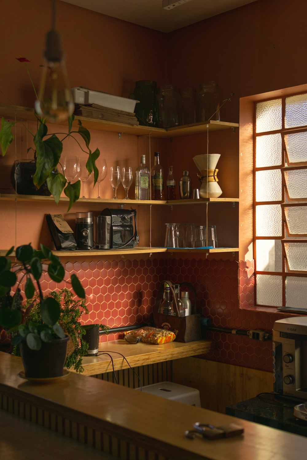 a kitchen with a shelf full of glasses and bottles