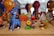 Intricately painted wooden animal figurines, including a blue deer, a colorful bird, and a jaguar, arranged on a wooden surface with various other vibrant crafts in the background.