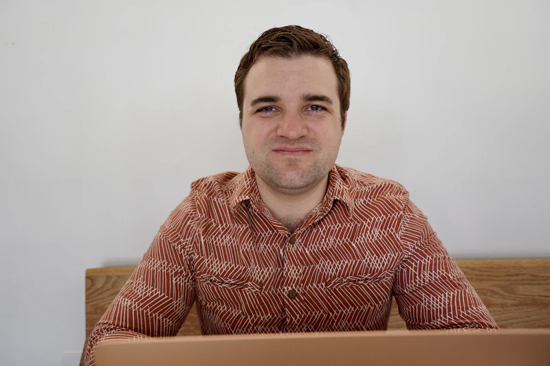young gay man sitting at a table
