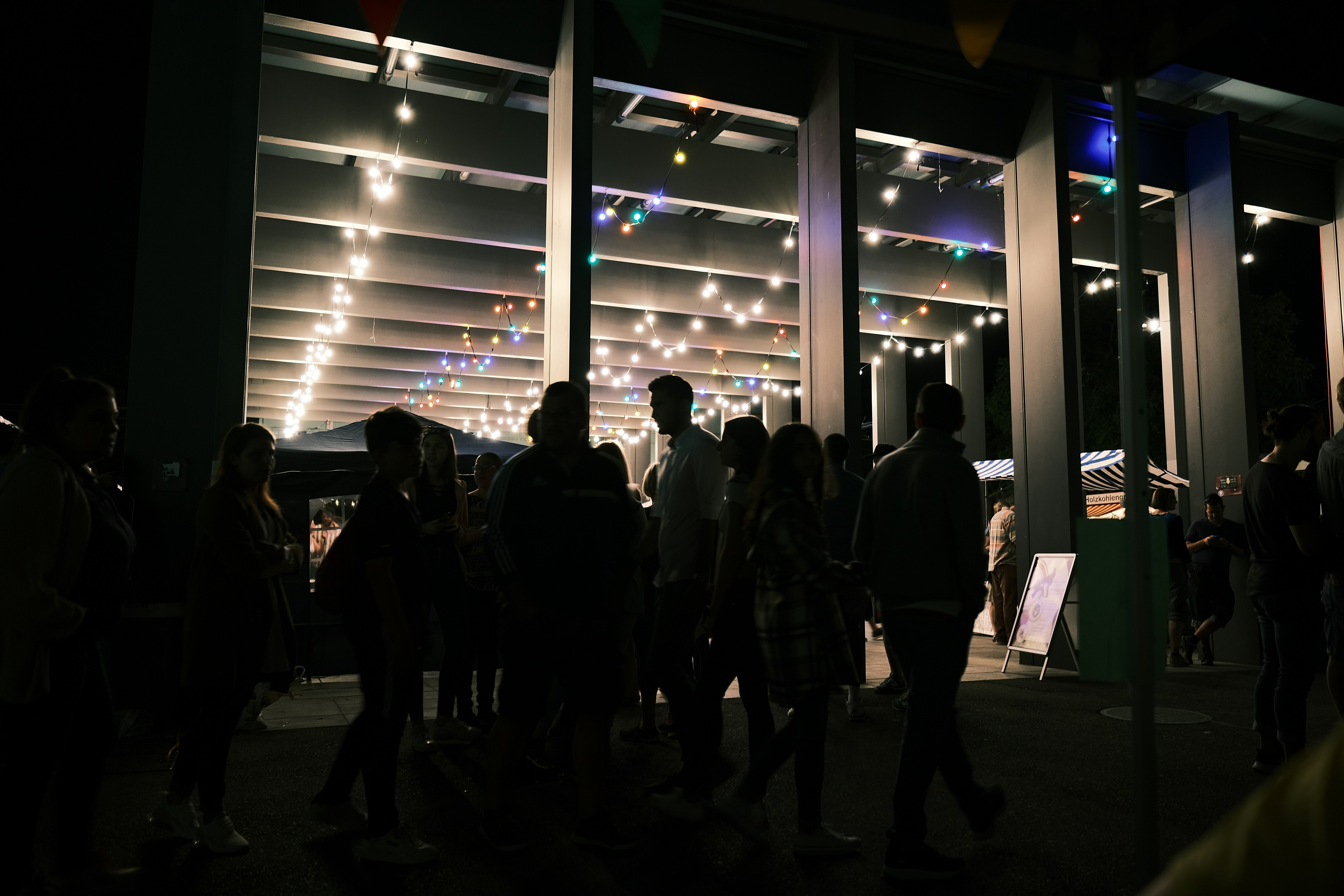 a group of people standing in a room with lights