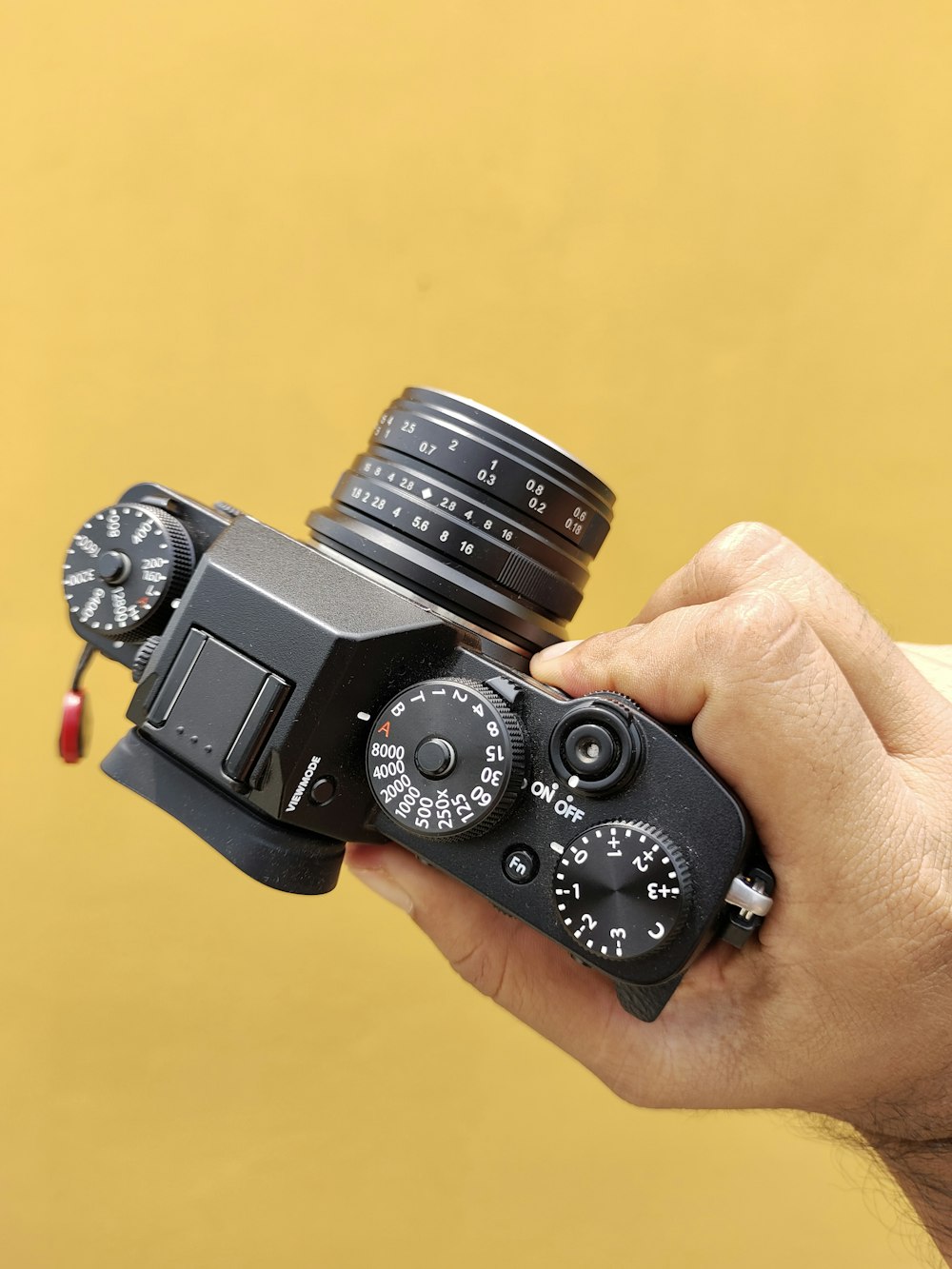 a hand holding a black camera