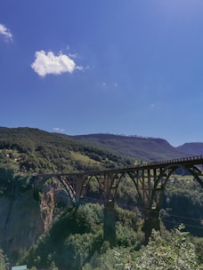 A newly built bridge spanning a wide valley with clear blue skies.