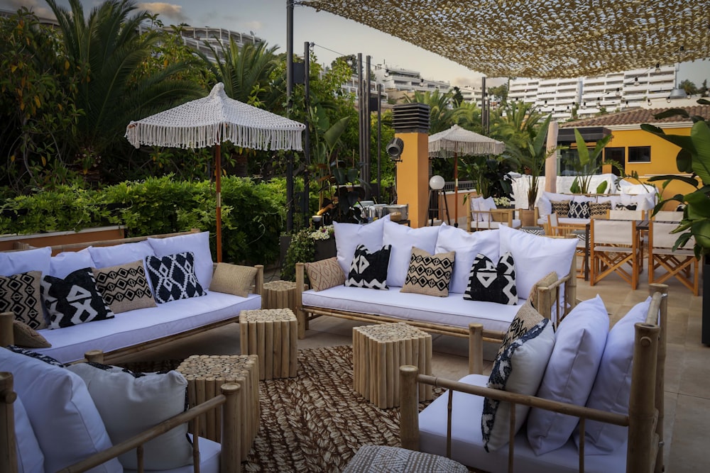 a lounge area with white couches and umbrellas