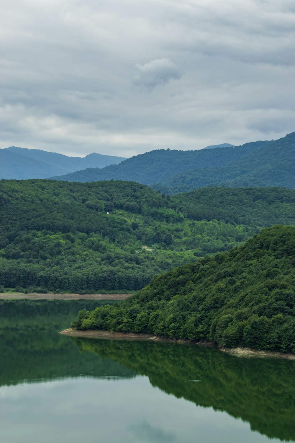 a lake surrounded by trees and mountains