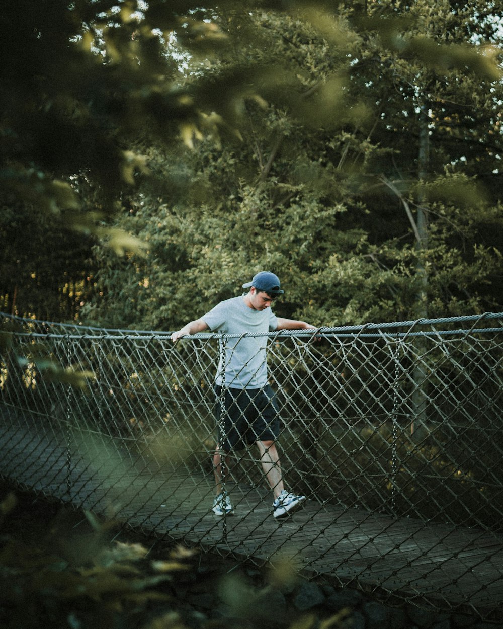 a man standing on a metal fence