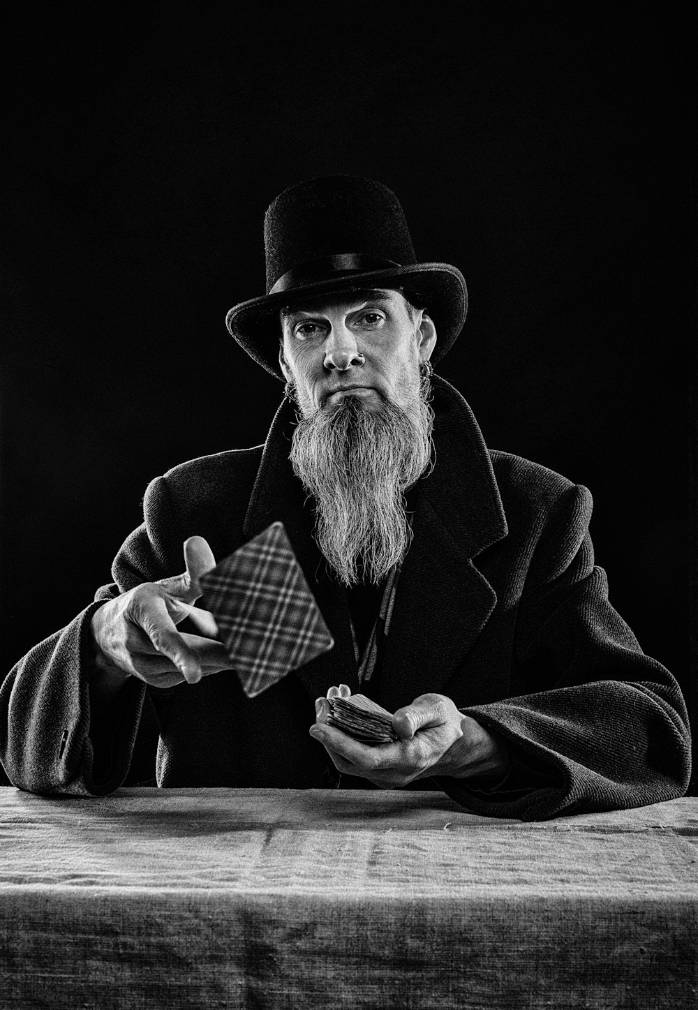 a man with a long beard and a hat holding a cigarette