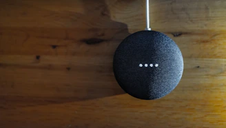 A family gathered around a smart speaker, laughing and interacting with voice commands.