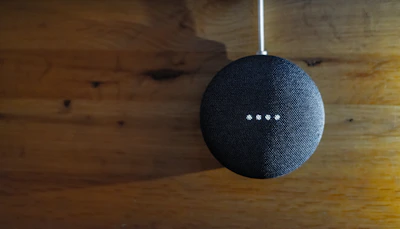 A family gathered around a smart speaker, laughing and interacting with voice commands.