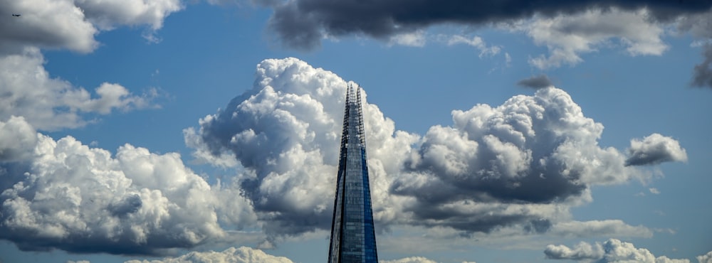 a tall building with clouds in the sky