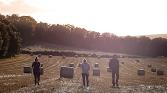a group of people standing in a field with luggage