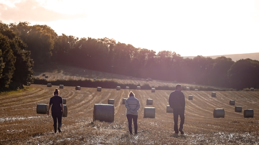 a group of people standing in a field with luggage