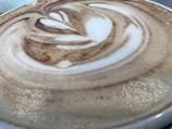 Close-up of a steaming cup of coffee with latte art.