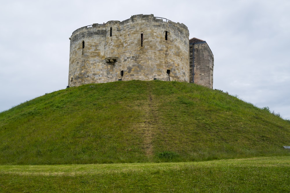 a stone castle on a grassy hill with York Castle in the background