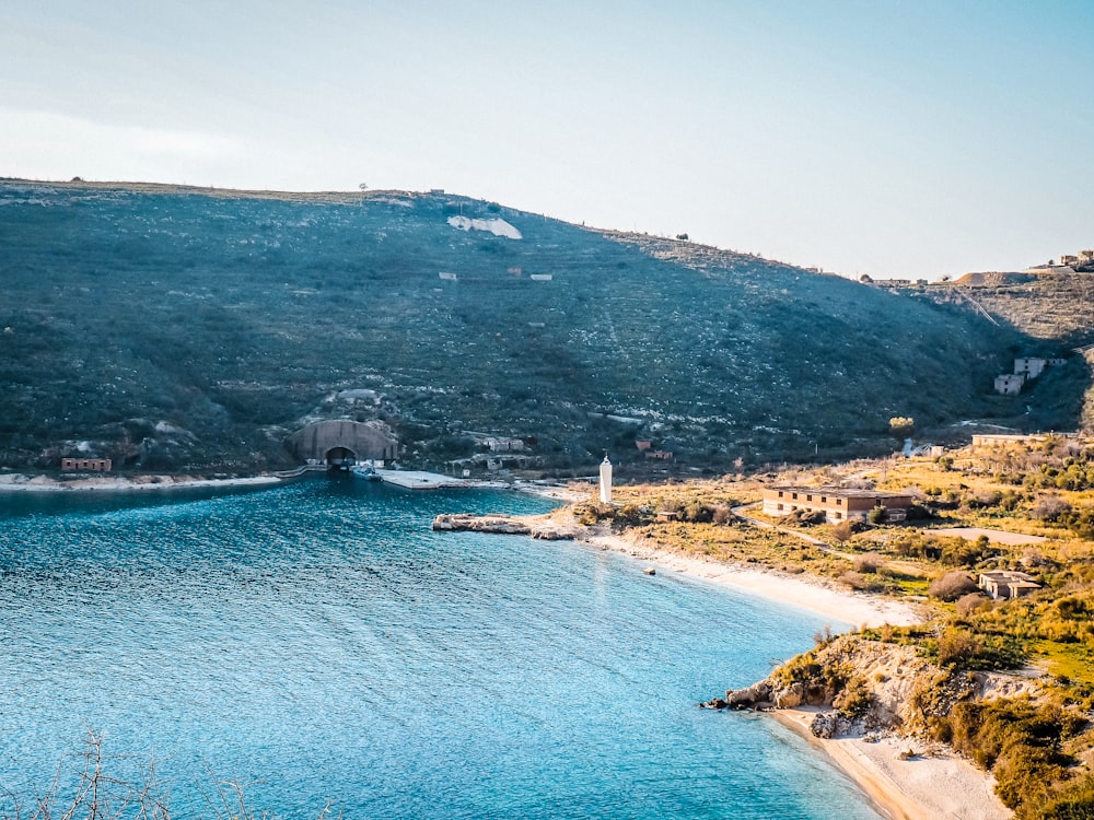 a body of water with buildings and hills around it