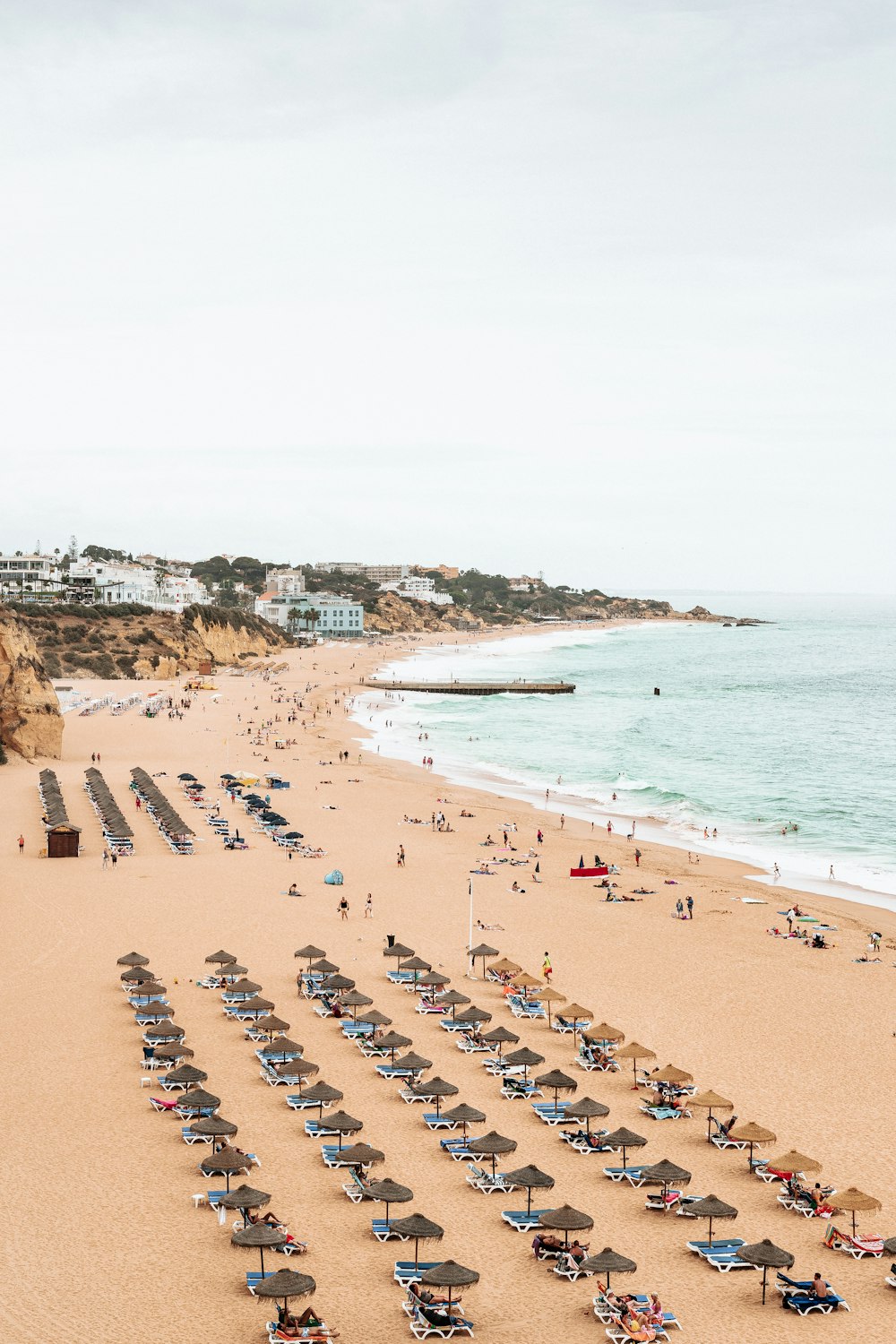 une plage avec beaucoup de monde et des parasols