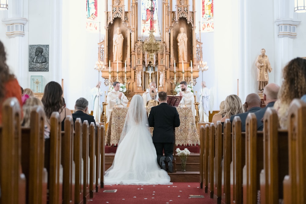 a bride and groom walking down the aisle in a church