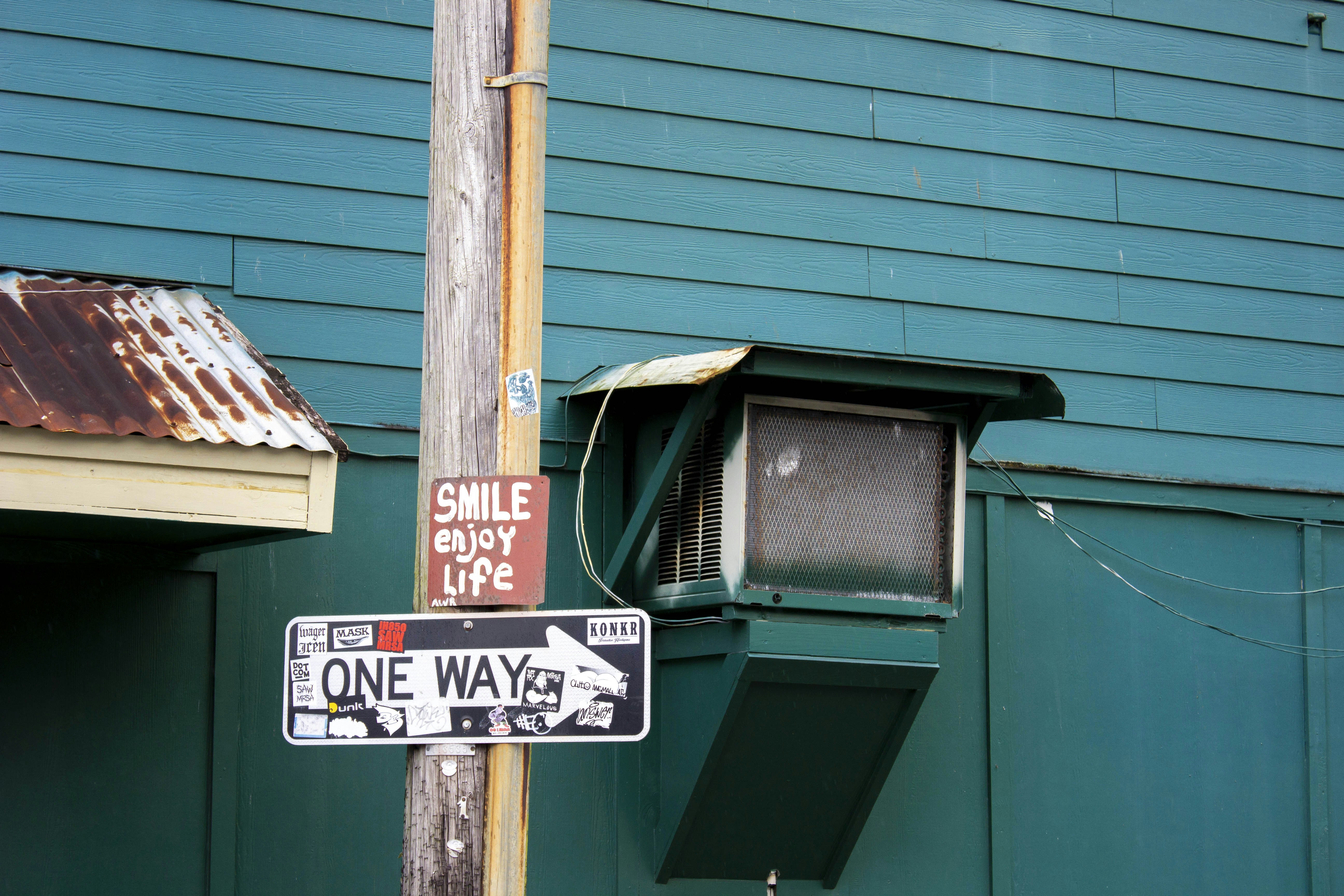 a street sign is posted on a pole, Smile in downtown Hilo