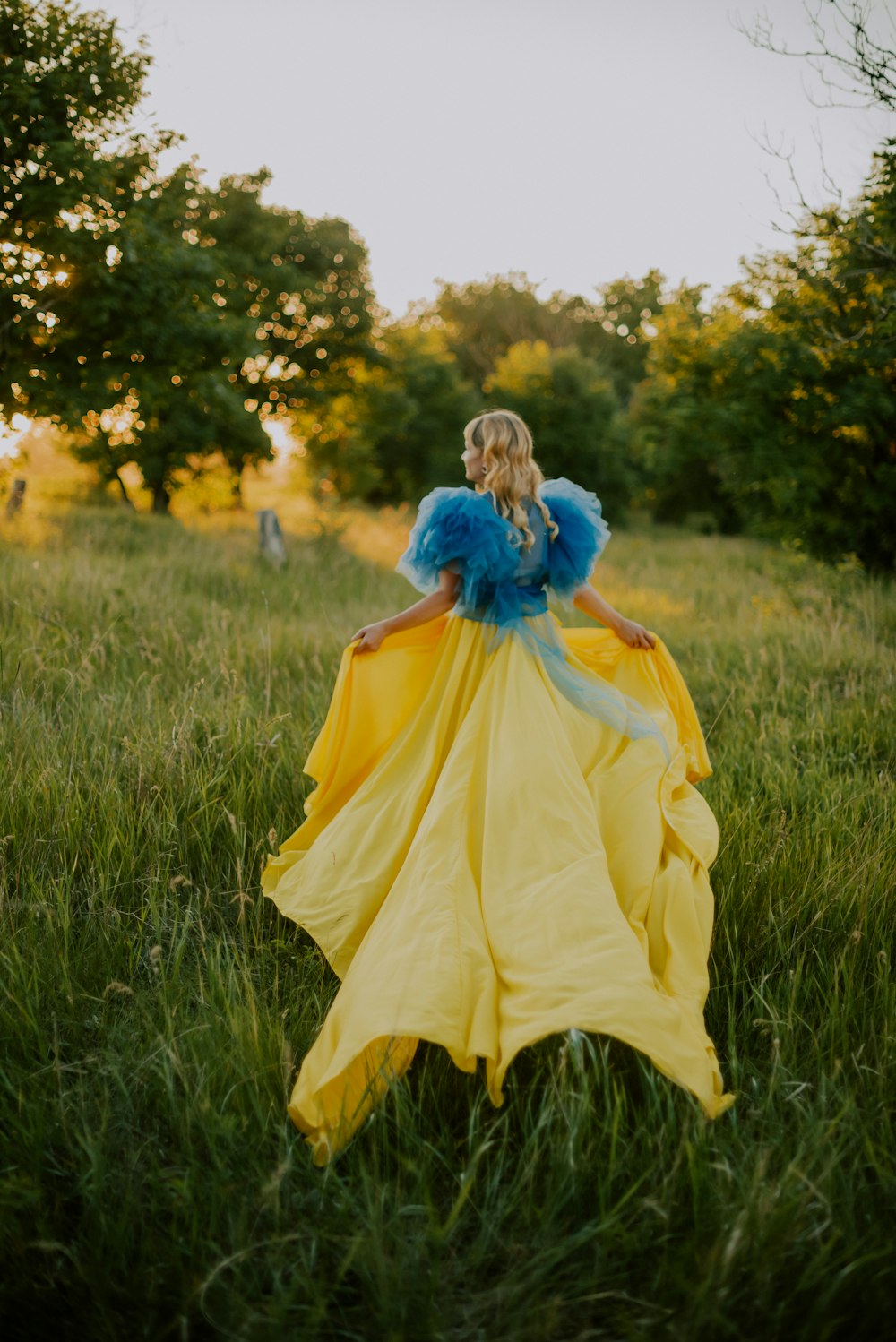 a person in a yellow dress in a grassy field