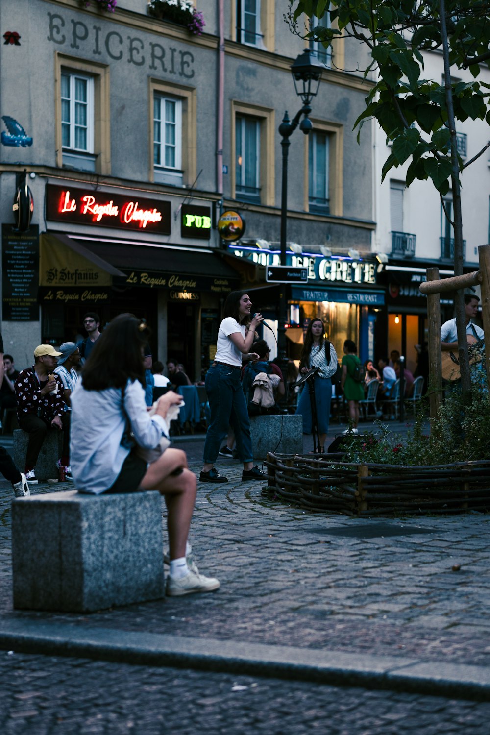 a person sitting on a bench in front of a store