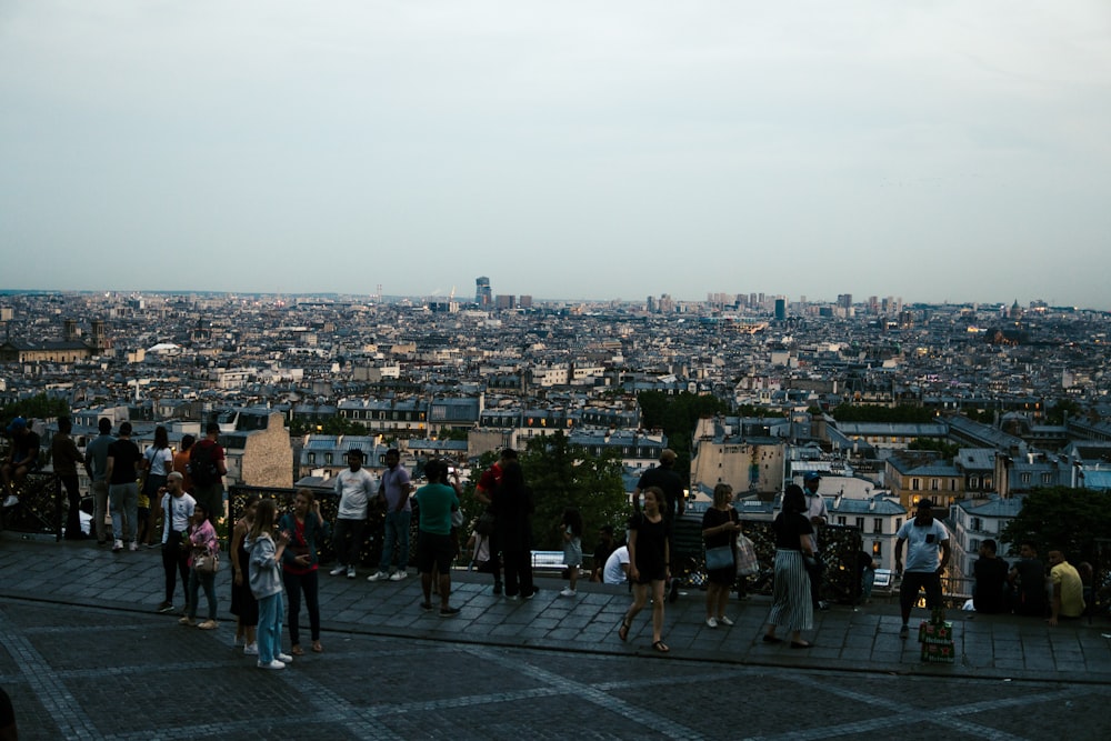a group of people standing on a rooftop overlooking a city
