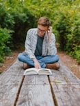 a person sitting on a bench reading a book