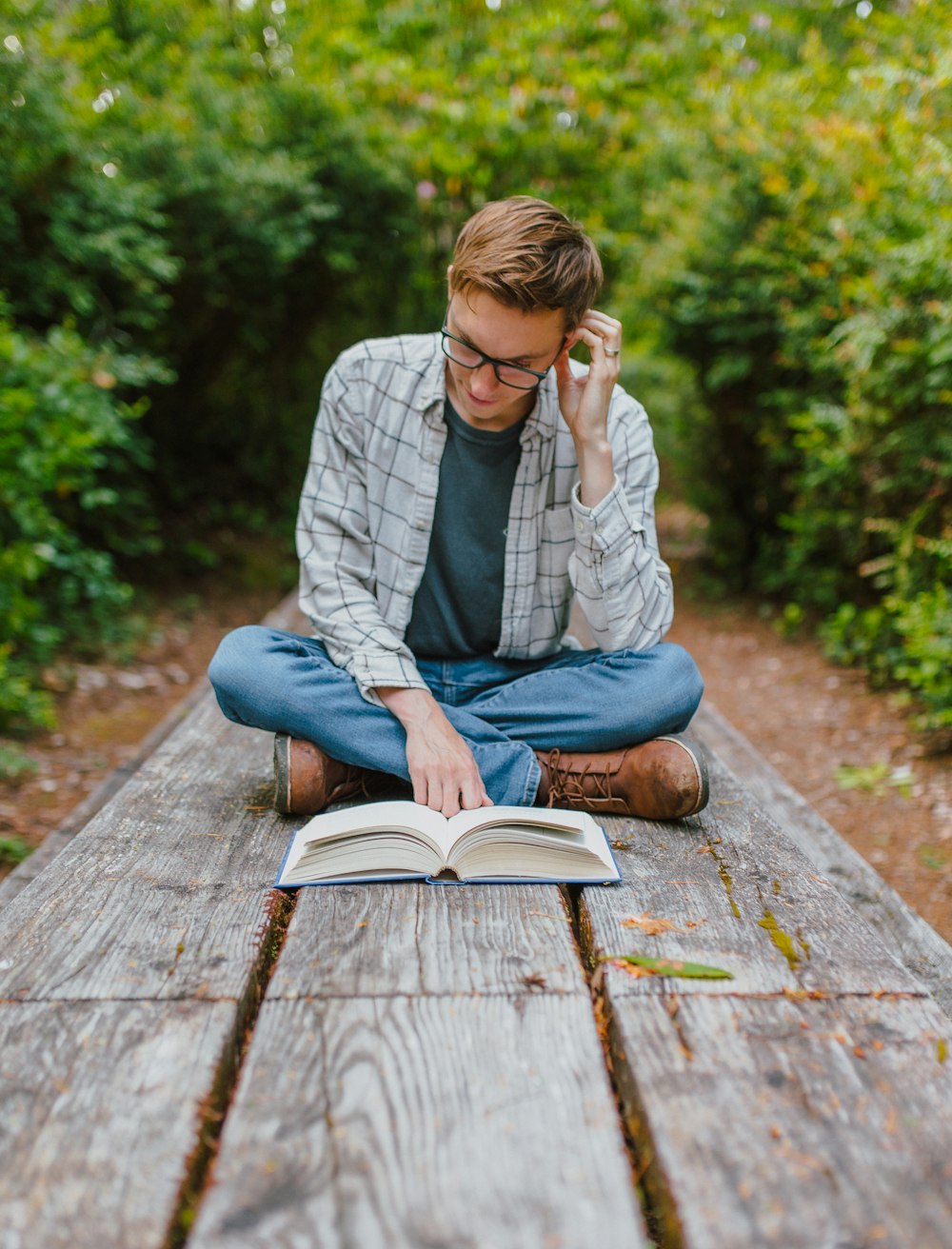 a person sitting on a bench reading a book