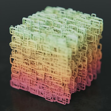 A complex, three-dimensional cube-shaped structure composed of interconnected, wireframe-like rectangular shapes. The structure features a gradient color scheme transitioning from shades of green at the top to yellow and pink at the bottom, set against a dark background.