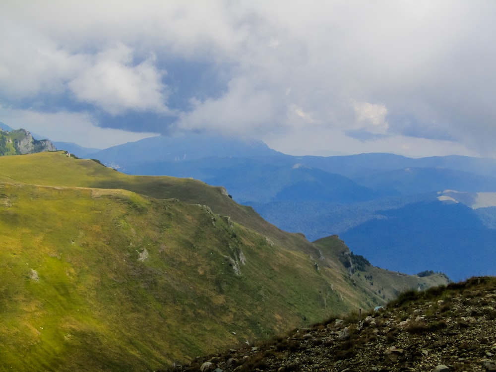 a grassy valley with mountains in the background