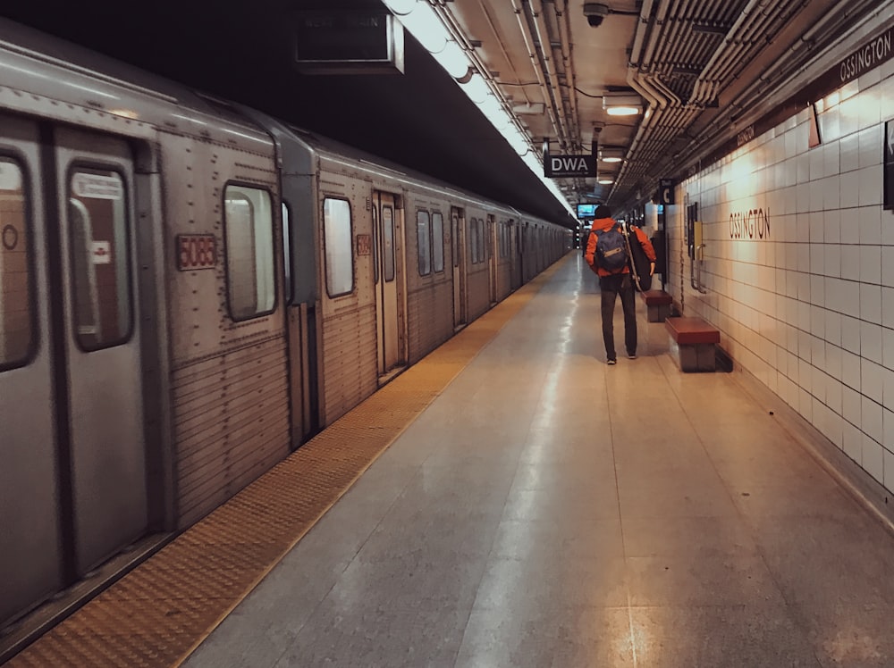 a person with a suitcase walking on a train platform