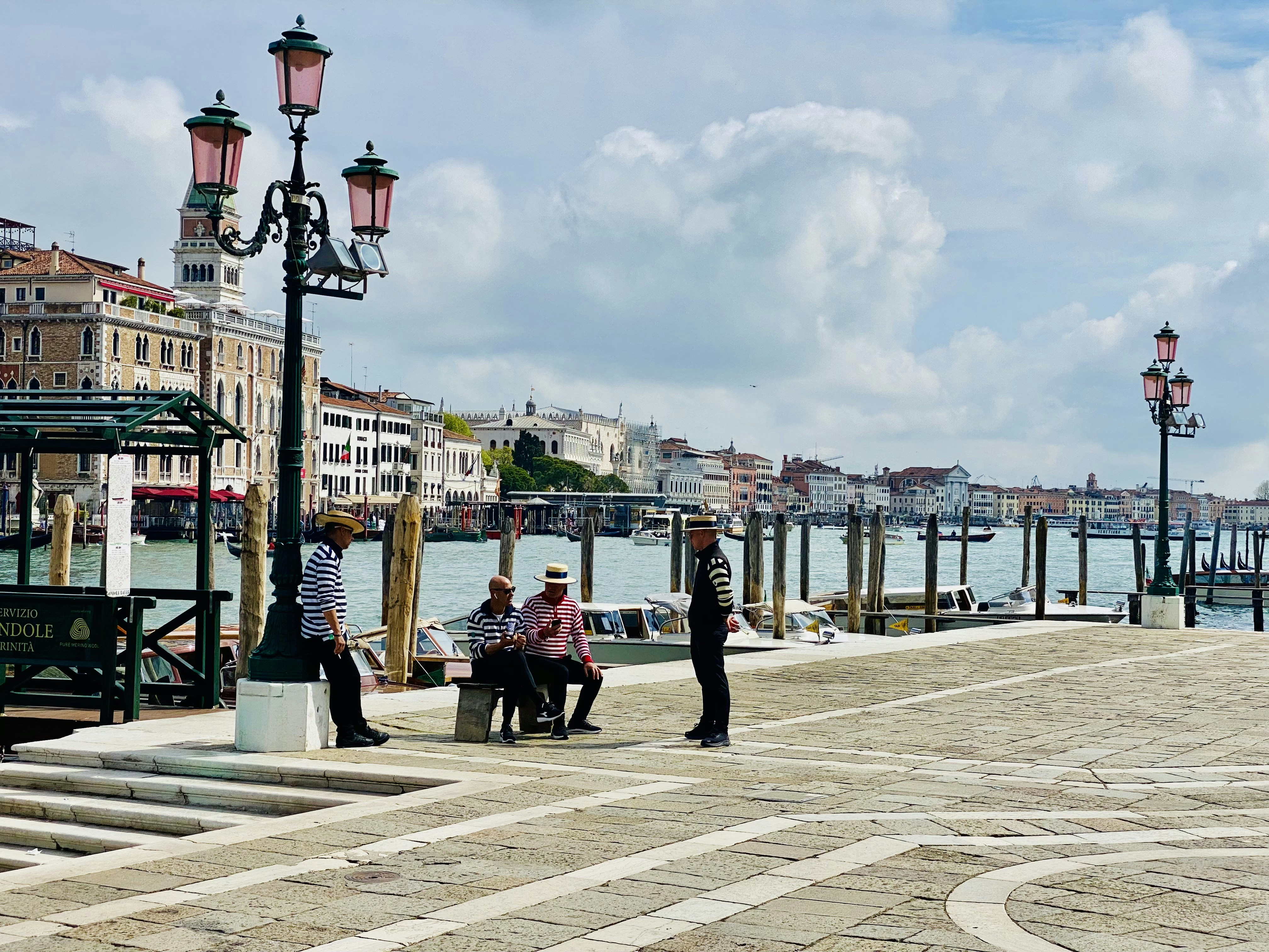a group of people sitting on a bench by a body of water