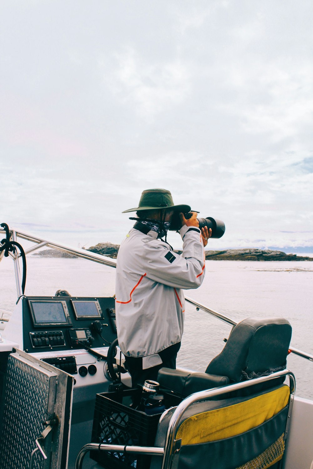 a person in a white coat and hat on a boat