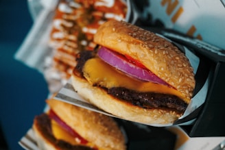 Close-up of a juicy Big Pepe's smashed burger with melted cheddar and sesame seed bun, vibrant colors reflecting the lively atmosphere of Pepe's Burger.