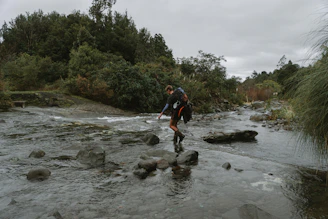 Close-up of a hiker crossing a crystal-clear glacial stream in Patagonia