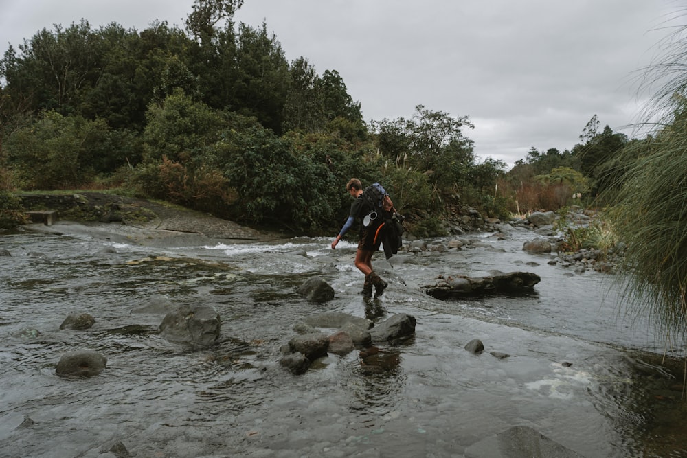 a man and woman walking in a river