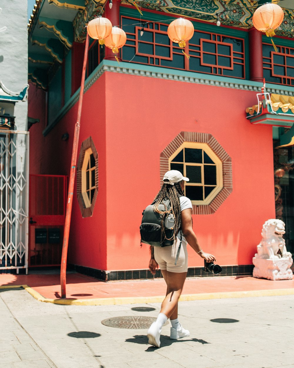 a person walking in front of a red building