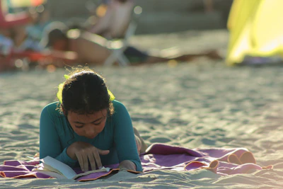 Kinderbücher — Kind liest ein Buch am Tisch