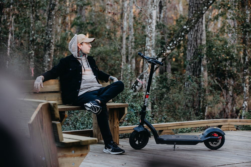 a person sitting on a bench with a scooter and a wheelbarrow