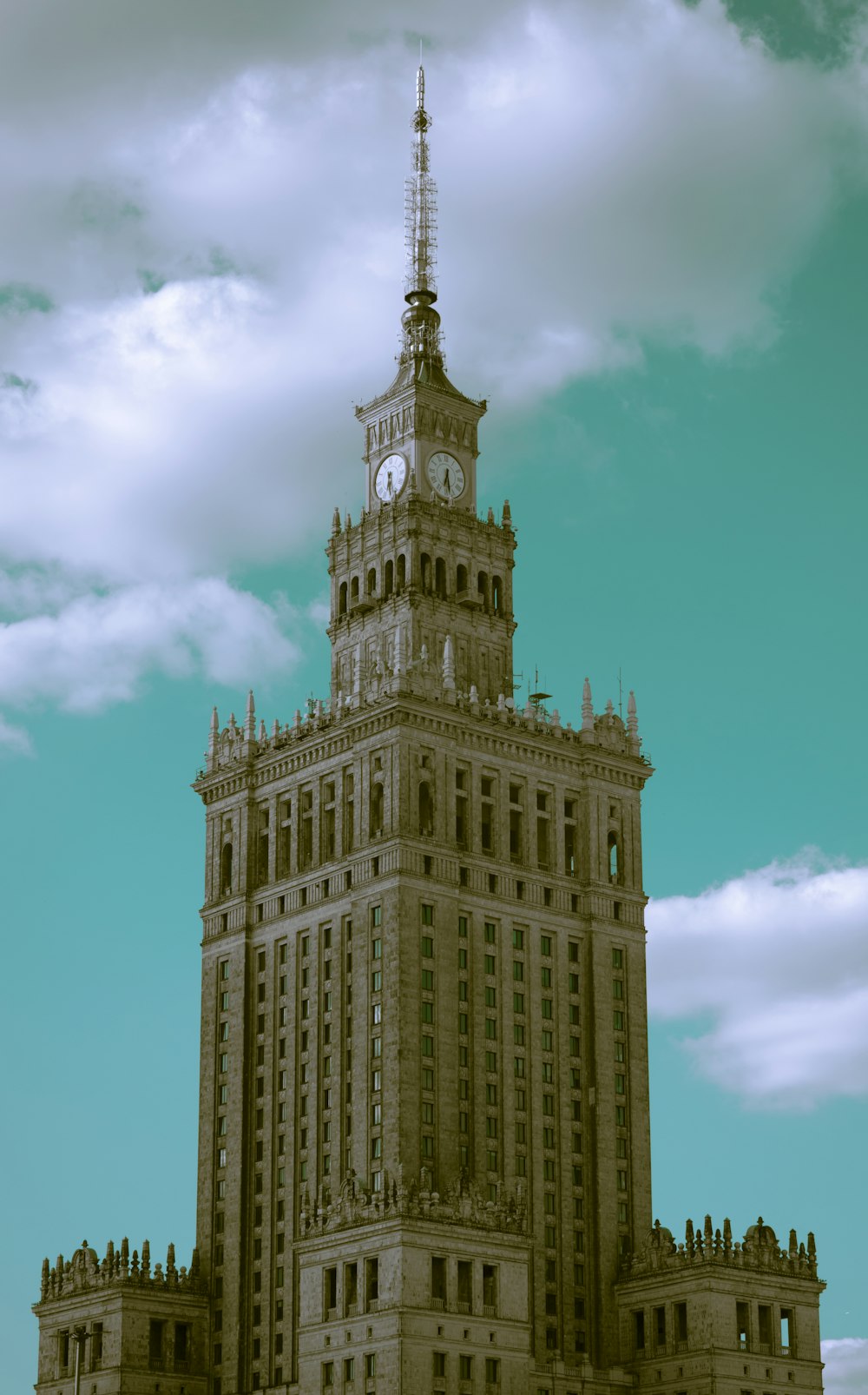 a large building with a clock tower with Palace of Culture and Science in the background