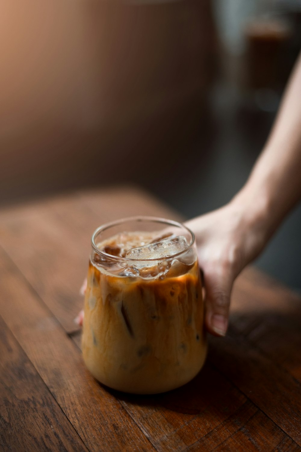 a hand holding a glass of liquid