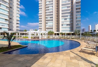 a pool in a courtyard with tall buildings in the background