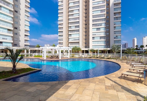 a pool in a courtyard with tall buildings in the background