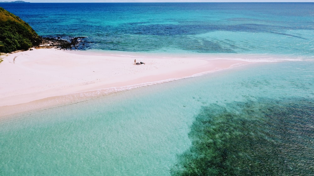 a beach with a couple of people swimming in the water