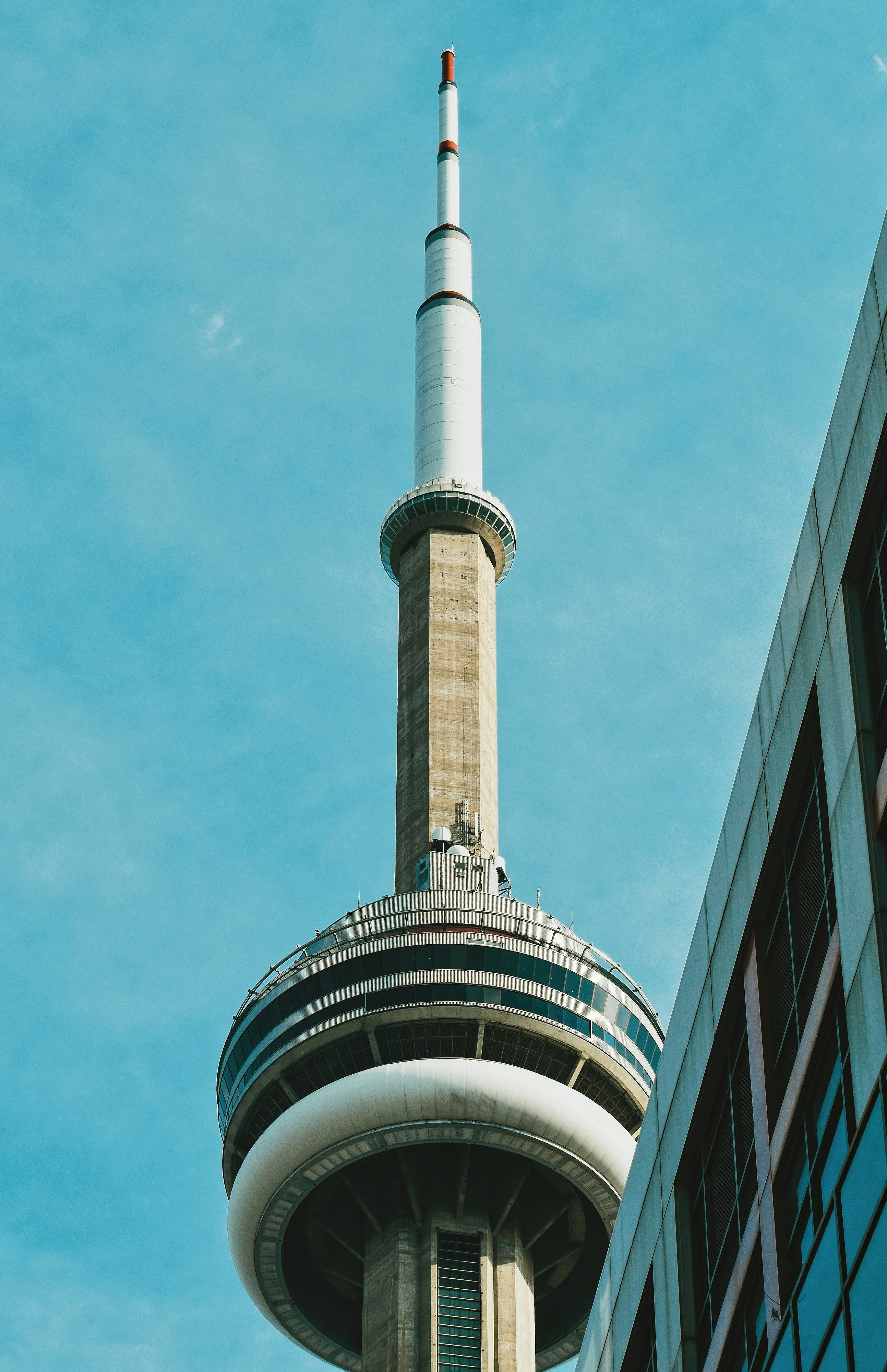 una torre alta con una parte superior cilíndrica con la Torre CN al fondo